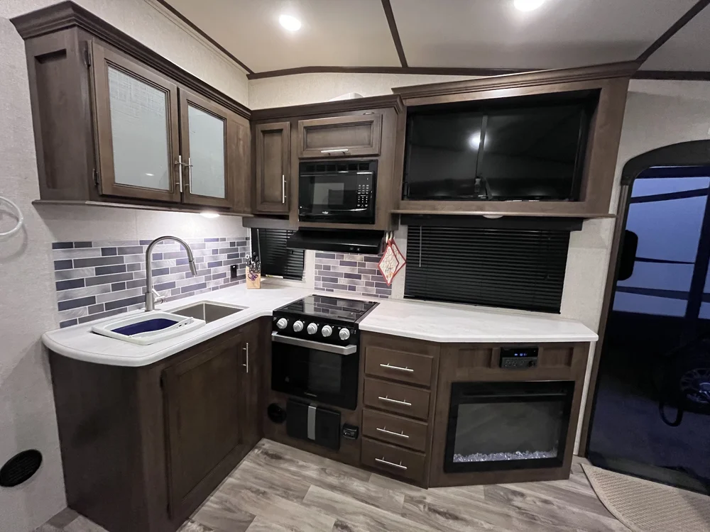 Full trailer kitchen with oven, microwave, TV and fireplace